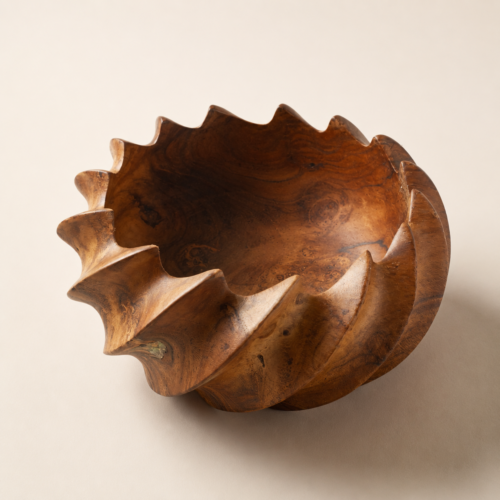 MOCCALO sculptural wooden bowl with flowing spiral ridges on a cream background